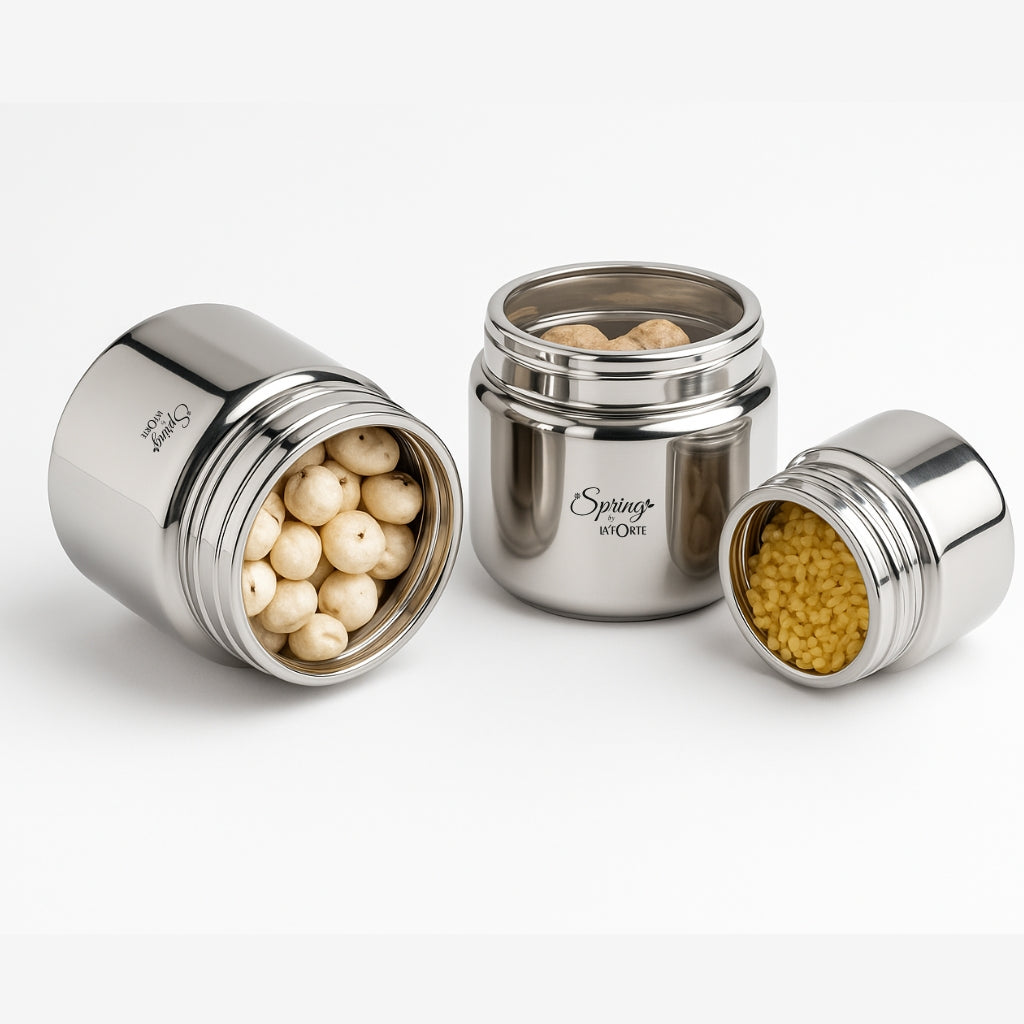 Three silver containers with food items on a white background